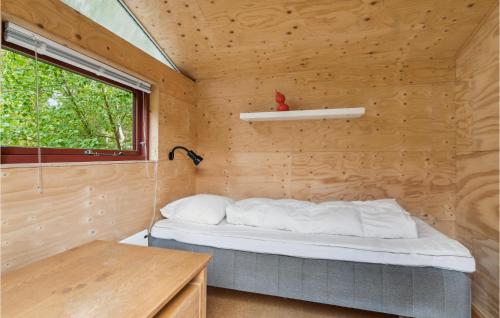 Cama en habitación pequeña con ventana en Cozy Home In Rrvig With Kitchen, en Rørvig