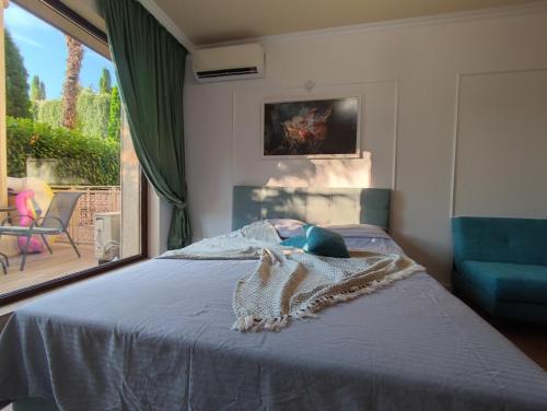 ein Schlafzimmer mit einem Bett mit einem blauen Sofa und einem Fenster in der Unterkunft Argisht Marina LUX Studio APT606 in Goldstrand