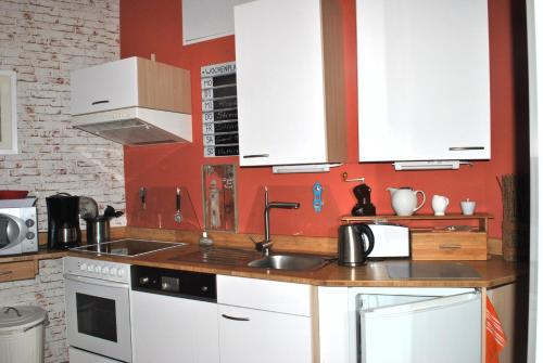 a kitchen with white cabinets and a sink at Ferienwohnung Warnemünde Altstadt (RC) in Warnemünde