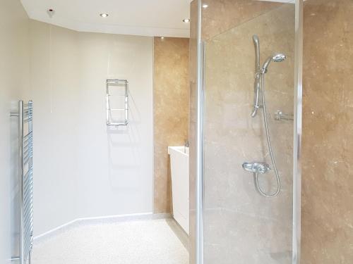 a shower with a glass door in a bathroom at The Potting Shed in Challoch