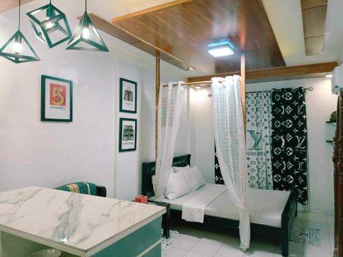 a bathroom with a bed and a sink in a room at Fabuluz Luxury at Princess Place in Malolos