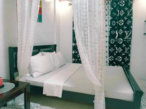 a bedroom with a bed with a canopy and curtains at Fabuluz Luxury at Princess Place in Malolos