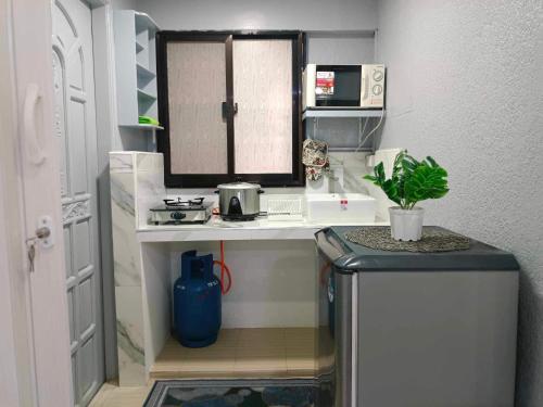 a small kitchen with a sink and a refrigerator at Fabuluz Luxury at Princess Place in Malolos