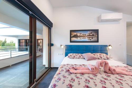 a bedroom with a large bed and a balcony at Villa Gräfin in Malinska