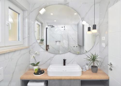 a bathroom with a white sink and a mirror at Luxury Apartments Luna in Tučepi