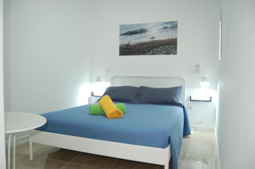 een slaapkamer met een bed met blauwe en gele kussens bij Seagull Estudios in Pozo Izquierdo