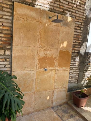 a stone wall with a shower in a garden at Casa da Vovó in Jericoacoara