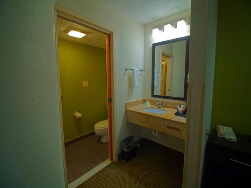 a bathroom with a sink and a toilet and a mirror at Sleep Inn Morganton Southeast in Morganton