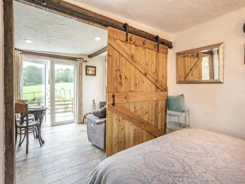 a bedroom with a sliding barn door and a bed at Molehill Lodge in Ammanford