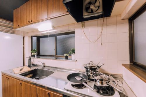 a small kitchen with a sink and a stove at Huge Osaka Castle House - local vibes quiet area in Osaka