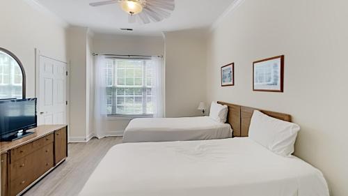 a bedroom with two beds and a flat screen tv at Golf and Beach Getaway Relaxation at its Finest in Pawleys Island