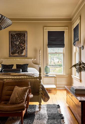 a bedroom with a bed and a chair and a window at Blind Tiger Burlington in Burlington