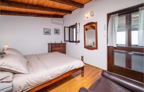 a bedroom with a bed and a couch and a window at Cozy Home In Plomin With Kitchen in Plomin