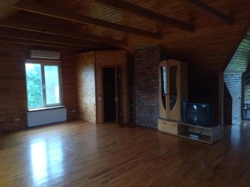 a living room with a tv and a wooden floor at ГРАНД in Szack