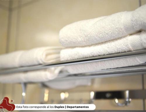 a stack of towels on a rack in a bathroom at Z Hotel Boutique in Puerto Iguazú