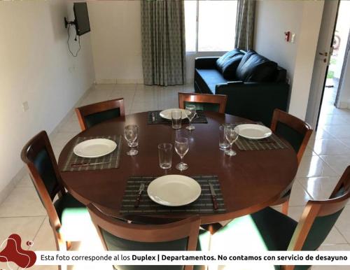 a dining room table with plates and wine glasses at Z Hotel Boutique in Puerto Iguazú
