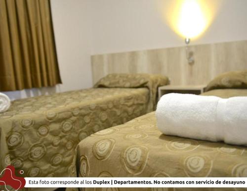 una habitación de hotel con 2 camas y una toalla en Z Hotel Boutique en Puerto Iguazú