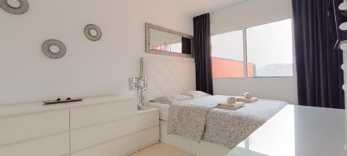 a white room with a bed and a mirror at Balcon Roque del Conde in Adeje