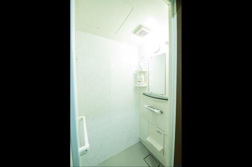a small bathroom with a white cabinet and a refrigerator at Guest house KURIHAI - Vacation STAY 09979v in Oita