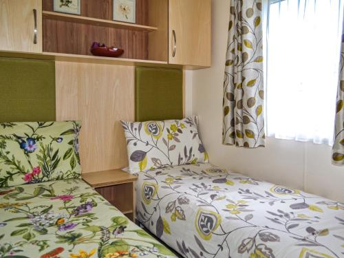 niewielka sypialnia z 2 łóżkami i oknem w obiekcie Summer Willow Lodge w mieście Tattershall