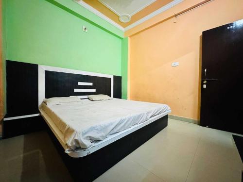 a bed in a room with green and yellow walls at OYO Hotel Verma Residency in Katra