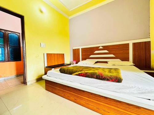 a bedroom with a large bed with a wooden headboard at OYO Hotel Verma Residency in Katra
