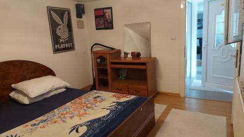 een slaapkamer met een bed, een dressoir en een spiegel bij Dina's house in Cazin