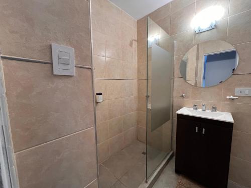 ein Bad mit einer Dusche, einem Waschbecken und einem Spiegel in der Unterkunft Departamento Nº 3 en complejo semiprivado! 2 habitaciones in San Martín