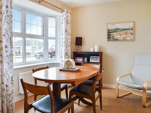 a dining room with a table and chairs and a window at Meadowfield View in Ryton