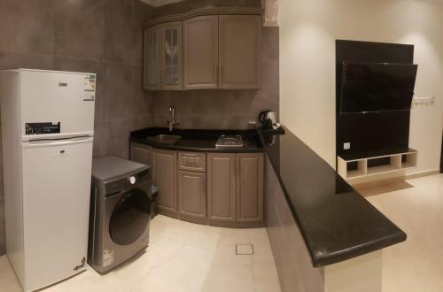 a kitchen with a white refrigerator and a dishwasher at شقة فندقية فاخرة in Taif