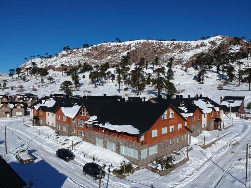 um grande edifício com neve no lado de uma montanha em Villa Maihue departamentos de montaña - Caviahue em Caviahue