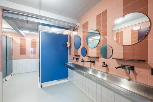 Baño con puerta azul y azulejos rosados en Hostel het Archief, en Zwolle