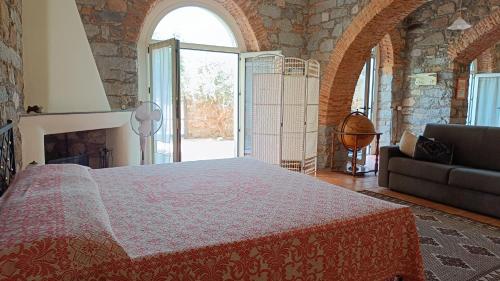 um quarto com uma cama grande e uma lareira em La Casa di Zia Zaira em Bari Sardo