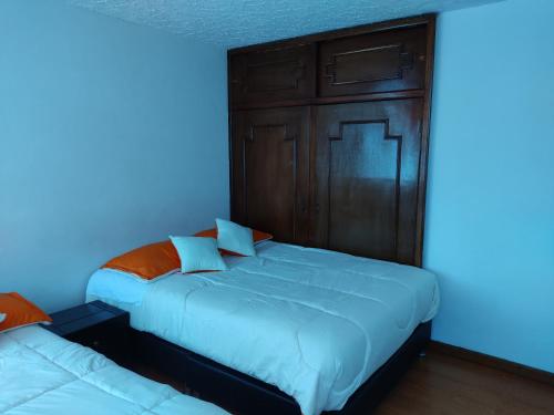 two beds in a room with blue lights at Hotel Dinnar in Ipiales