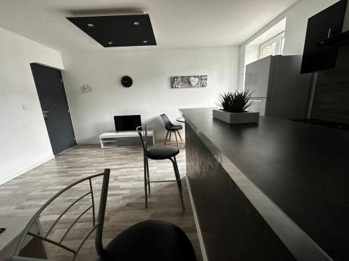 - un salon avec un comptoir et des chaises dans l'établissement Studio - THIERVILLE - Proche Régiment - Stationnement facile - Géré par Presta-Zen'Services, à Thierville-sur-Meuse