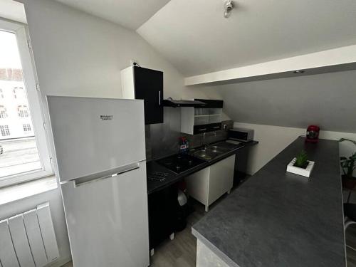 een kleine keuken met een koelkast en een fornuis bij Très beau studio in Thierville-sur-Meuse