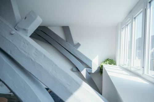 eine weiße Treppe in einem Gebäude mit Fenster in der Unterkunft Appartement Condé hyper centre-ville in Charleville-Mézières
