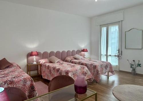 Comfort Accommodation Room في بيرغامو: غرفة فندقية بسريرين وطاولة زجاجية