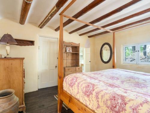 1 dormitorio con cama de madera en una habitación en El Nido Lane Tesuque, 1 Bedroom, Sleeps 2, Private Yard, WiFi, Washer/Dryer, en Santa Fe