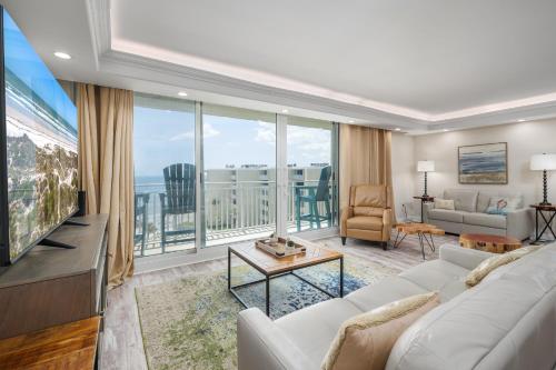 un salon avec un canapé blanc et une grande fenêtre dans l'établissement Pelican Condo B602, à New Smyrna Beach