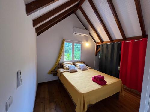 1 dormitorio con 1 cama en una habitación con ventana en Villa au calme avec Jacuzzi, Villa Le Boursoie, en Les Abymes