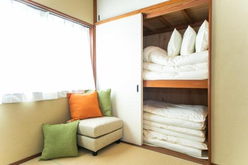 een kamer met een kast met een stoel en handdoeken bij ナガシマリバーサイドリゾート - Vacation STAY 94113v in Kuwana