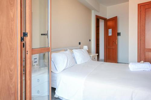 a bedroom with a white bed and a mirror at Il Porticciolo in Scilla