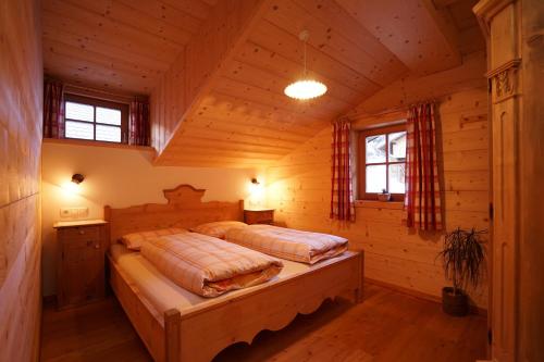 a bedroom with two beds in a log cabin at Unterhabererhof in Santa Maddalena in Casies