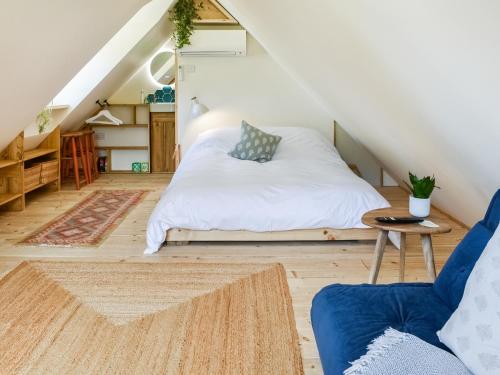 a bedroom with a bed and a chair in a attic at Hazel Nook in Trotton