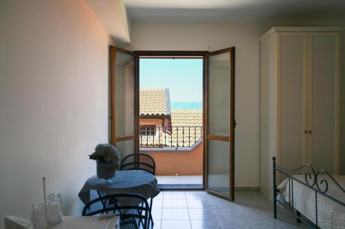 a room with a table and a view of a balcony at Il Porticciolo in Scilla
