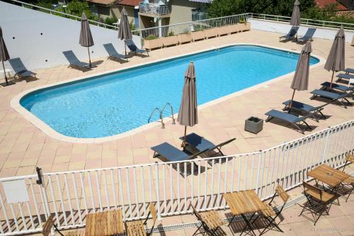 an overhead view of a swimming pool with chairs and umbrellas at Hôtel Le Refuge des Sources in Digne-les-Bains