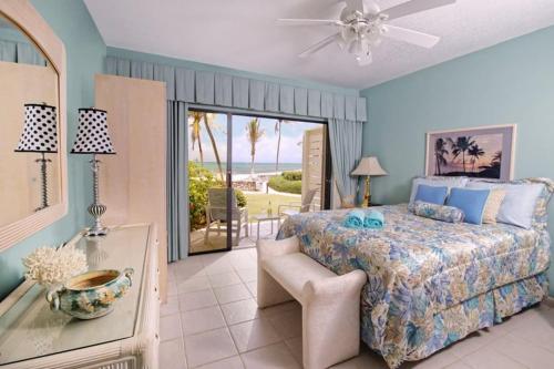 a bedroom with a bed and a view of the ocean at Beach Living at Villas Pappagallo Beachfront 22 in West Bay