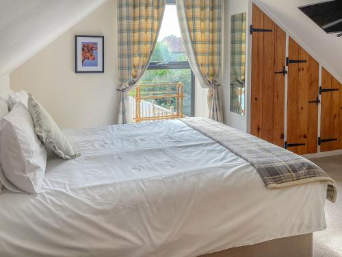 a white bed in a room with a window at The Stable in Bridgwater