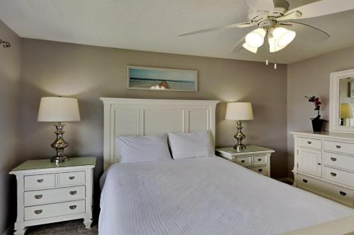 een slaapkamer met een wit bed en 2 nachtkastjes bij Seascape 204 in Orange Beach